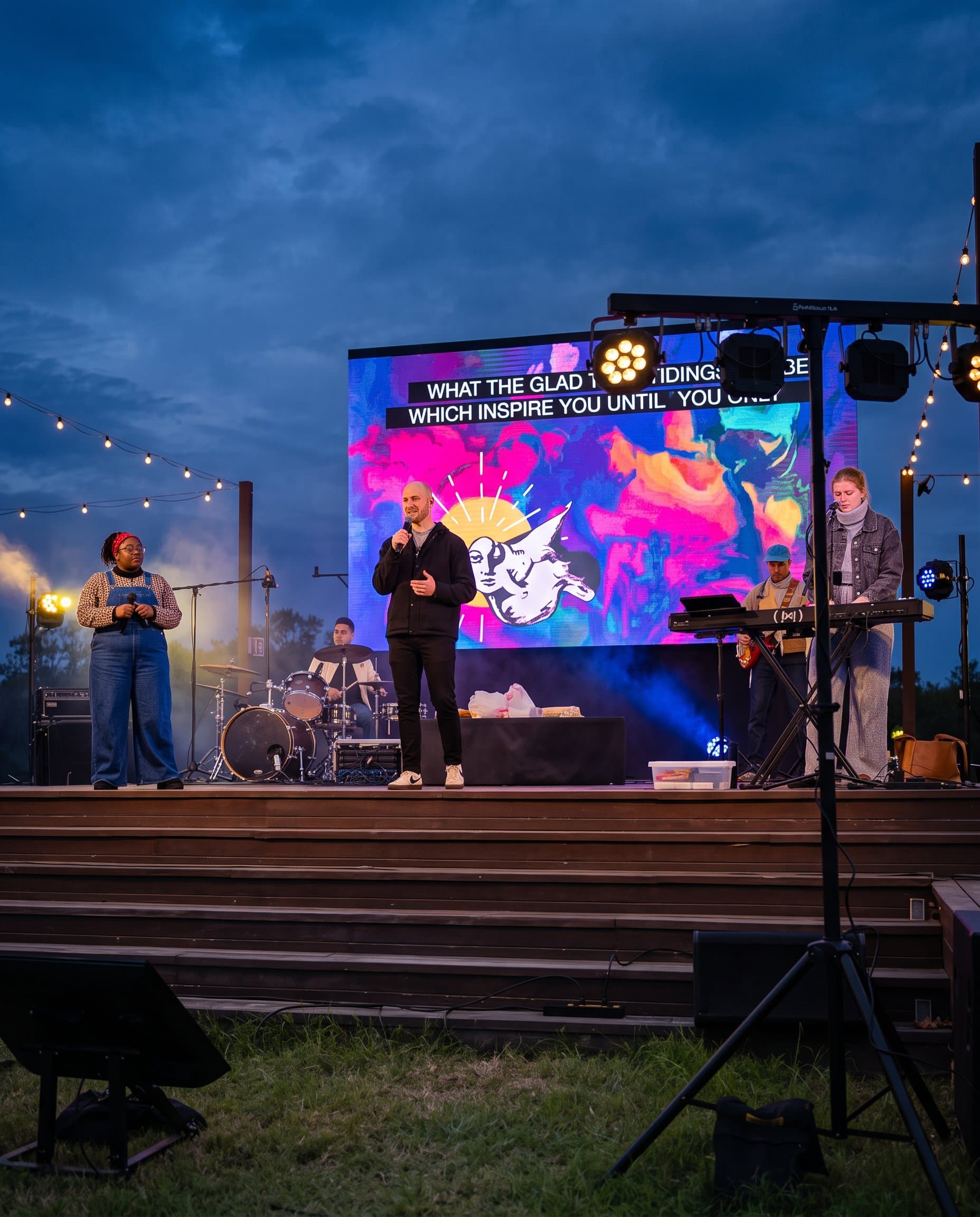 A full band performing on an outdoor stage